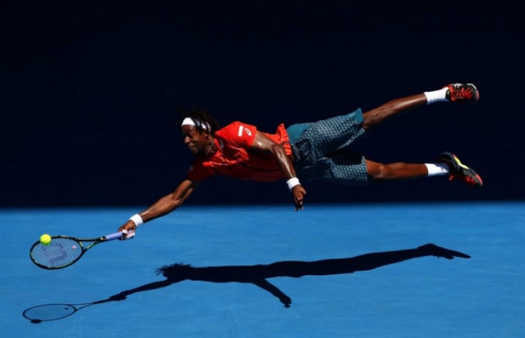 Gaël Monfils voa para salvar bola em Melbourne. Foto: Tennis Australia/Ben Solom
