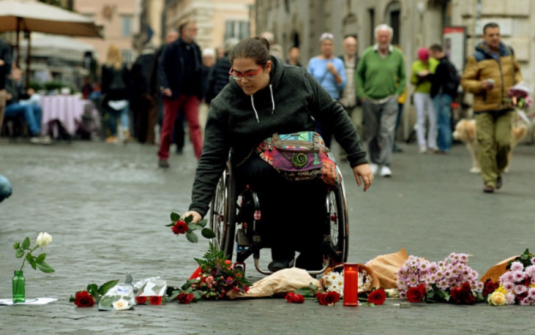 Mulher presta homenagem à s vÃtimas dos atentados em Paris (Foto: AFP)