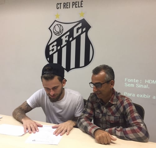 Lucas Lima ao lado de seu pai lendo a proposta do Santos, no CT Rei Pelé (Foto: Arquivo pessoal)