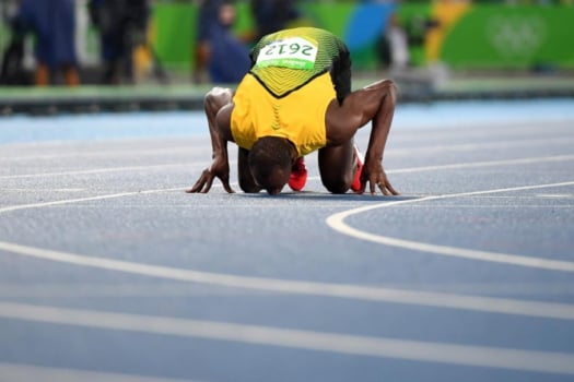 Bolt, o mito, beija o chão do Estádio Olímpico Nilton Santos após mais um ouro