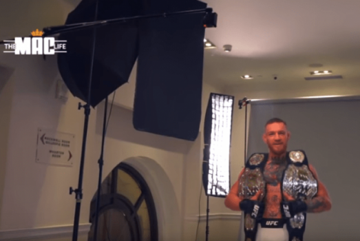 Conor McGregor posa com um cinturão em cada ombro antes do UFC 205