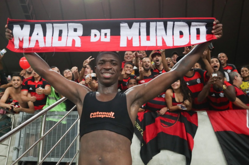 Vinicius with a scarf which says Flamengo is the biggest in the world
