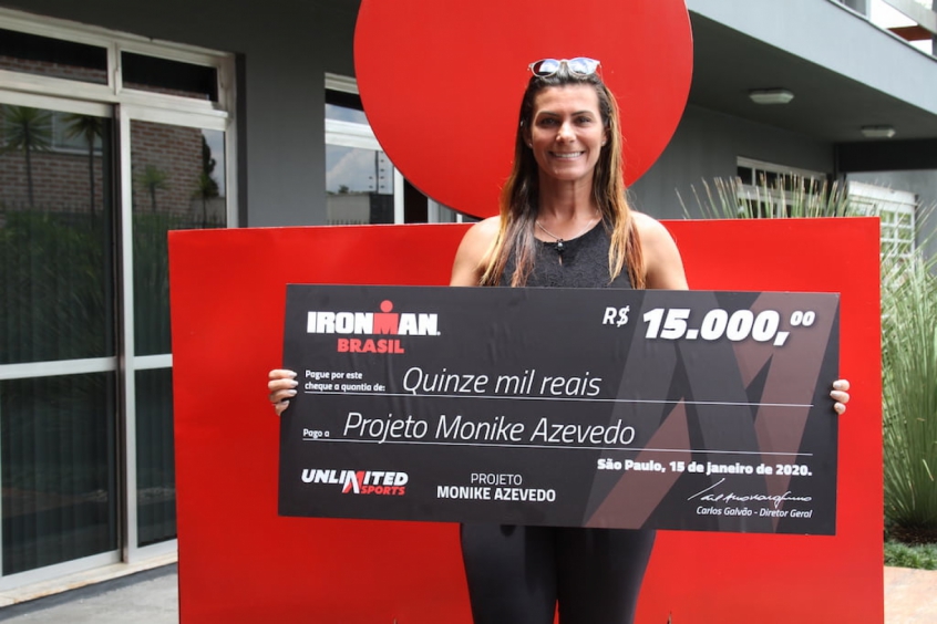 Monike Azevedo com o cheque da doação do Bazar Solidário Ironman Brasil. (Divulgação)