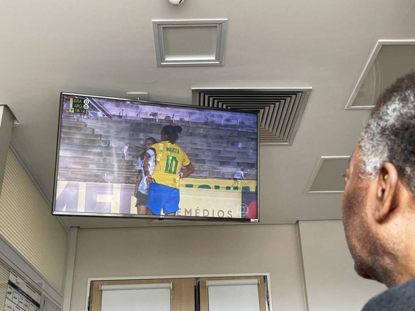 Pelé viendo el partido de la selección brasileña de mujeres