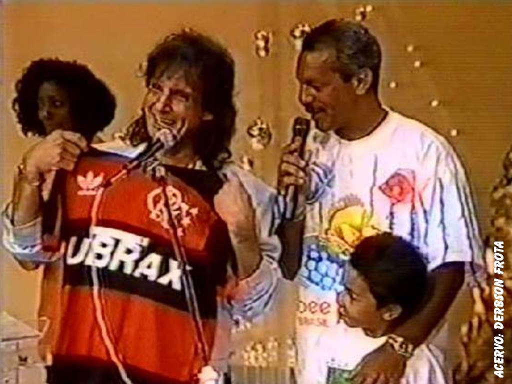 JÚNIOR entrou em campo na parte da tarde programa "Viva Luz", exibida ao vivo no dia 25 de dezembro de 1991 . O meio-campista, que tinha sido campeão carioca dias antes, entregou um Manto Sagrado para o cantor, que brincou: "de repente dá até vontade de vestir...". Assim que o craque começou a conversar com Roberto, a banda regida pelo maestro Eduardo Lages tocou o hino do Flamengo.