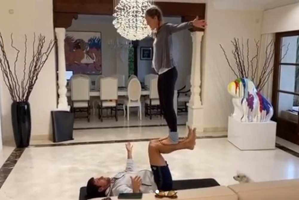 O sérvio Novak Djokovic, ao lado de sua mulher Jelena, lançou um desafio de yoga em duplas. No exercício, Djokovic deita com as costas no chão, ergue as pernas em um ângulo de 90º e sua mulher se equilibra sobre elas.