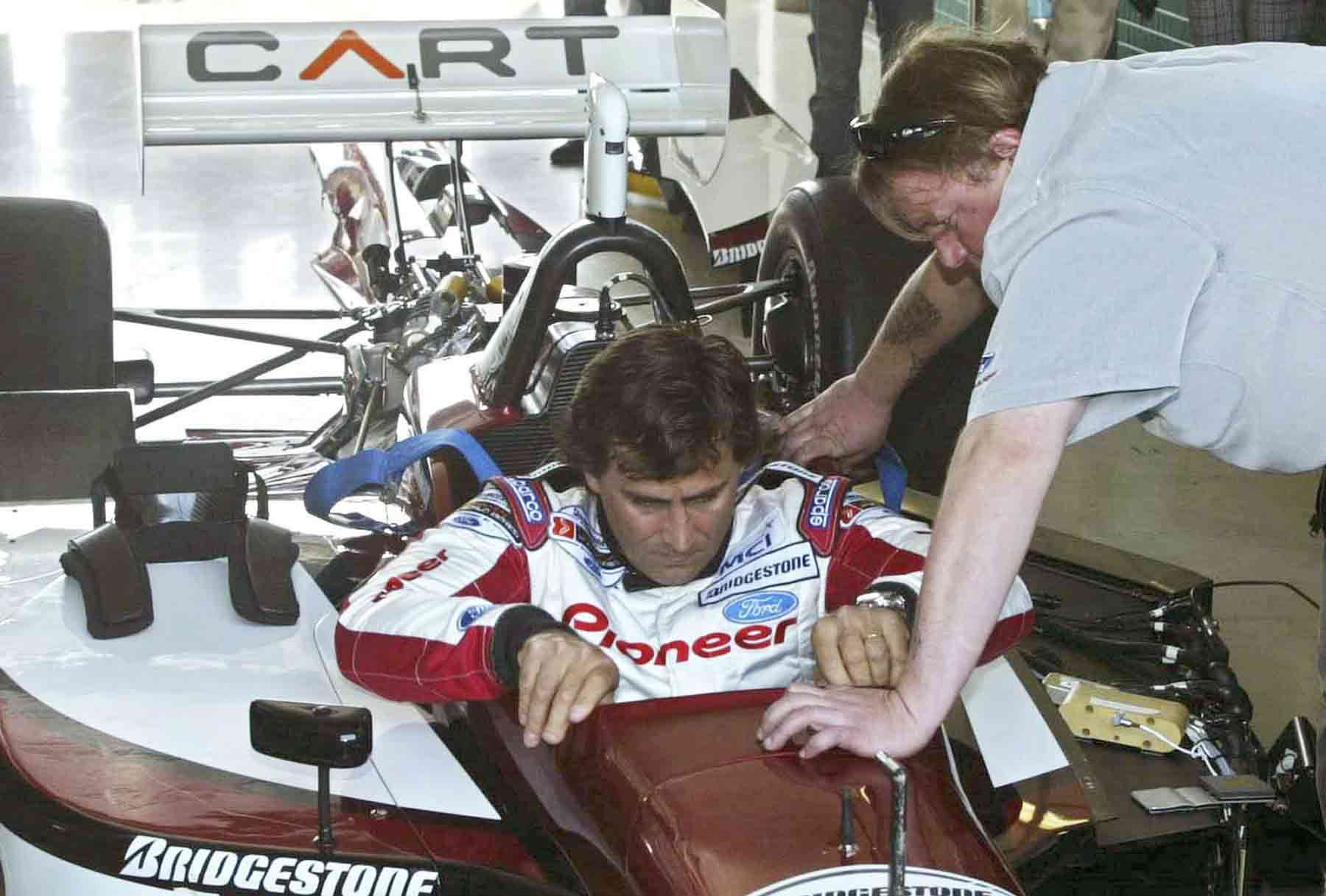 Zanardi é auxiliado para entrar no carro da Indy de 2003, onde foi homenageado no oval da Alemanha