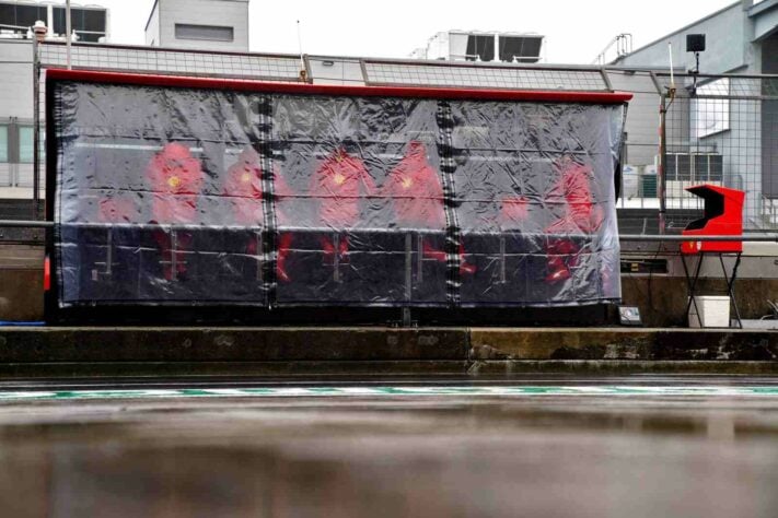 Membros do pit-wall da Ferrari se protegeram da chuva na Alemanha 