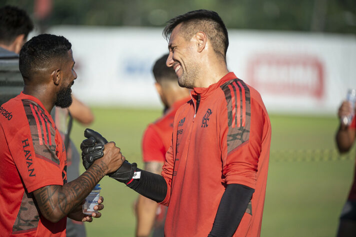 O goleiro Diego Alves ri no momento que cumprimenta Rodinei em um dos campos do Ninho do Urubu.
