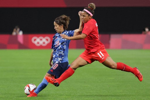 Parecendo quase voar, jogadora do Canadá tenta roubar a bola.