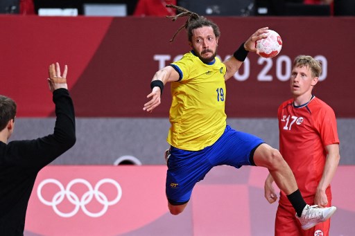 Jogador de handebol do Brasil parece voar na tentativa de marcar um ponto.