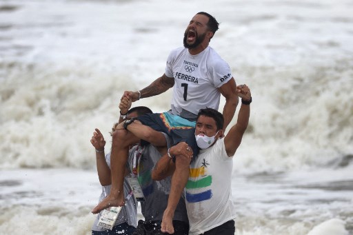 O surfista brasileiro Ítalo Ferreira é ovacionado ao chegar na praia vitorioso pelo surfe em Tóquio.