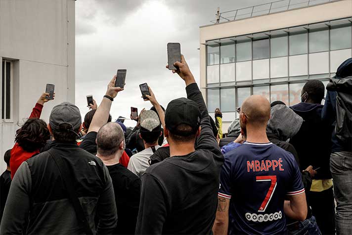 Diversos fãs filmam os cânticos que são entoados pela torcida que está presente no entorno do Parque dos Príncipes