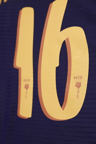 Detalhe da fonte da numeração da camisa, que aparece na cor dourada, assim como o escudo do clube.