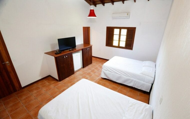 Dormitório do centro de treinamento, com TV e ar condicionado.