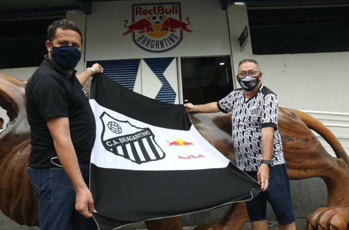 Torcedores do Bragantino mostram bandeira com o escudo do Clube Atlético Bragantino e da multinacional Red Bull.