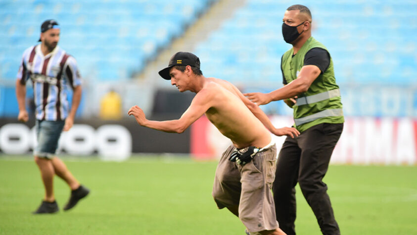 Confusão na Arena - Torcedores do Grêmio protagonizaram cenas lamentáveis após a derrota por 3 a 1 para o Palmeiras no Brasileirão. Depois do apito final, gremistas invadiram o gramado e provocaram atos de selvageria dentro da Arena. Além de seguranças agredidos, a cabine do VAR também foi deteriorada.