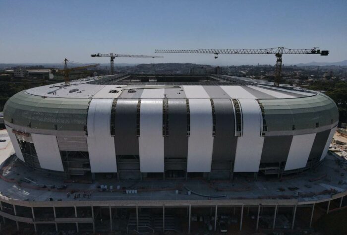 A Arena MRV, novo estádio do Atlético-MG está com as obras em andamento a todo vapor e chegou em 75% de conclusão em agosto de 2022. As cadeiras já começaram a ser instaladas e estão sendo realizados os detalhes finais na moderna arena. Ela está sendo construída nas proximidades do bairro Califórnia, região Noroeste de Belo Horizonte, com capacidade para 46 mil torcedores. As obras devem ser finalizadas em outubro deste ano e a inauguração está prevista para 25 março de 2023, dia do aniversário do clube. O custo estimado é de R$ 560 milhões. Veja imagens atualizadas da obra - e como o estádio ficará, ao fim da galeria!