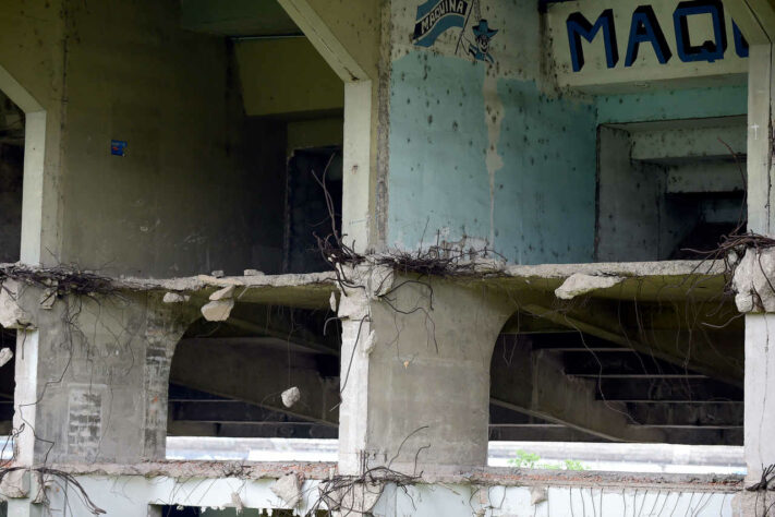 Alguns vergalhões, parte da estrutura do estádio, estão à mostra na área externa. 