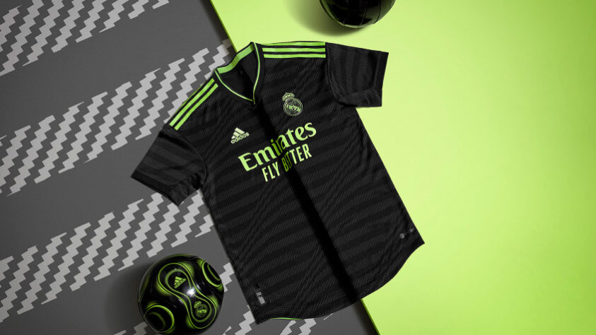 REAL MADRID - A nova camisa três do Real Madrid traz a cor preta predominante e tem como destaque, faixas onduladas em tom sobre tom, formadas por linhas diagonais, que tem como inspiração a fachada do Estádio Santiago Bernabeu, que recentemente passou por uma importante modernização.