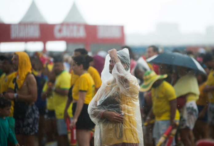 A capa de chuva transparente não apagou o verde e amarelo dos torcedores. 