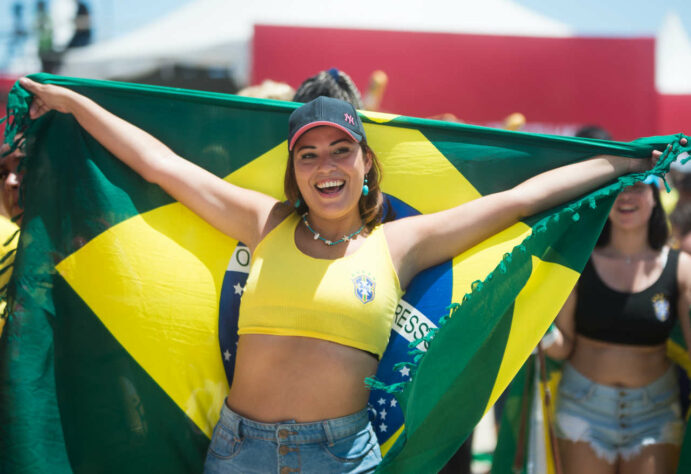 Envolvida na bandeira do Brasil, a torcedora esbanjou felicidade antes do início da partida.