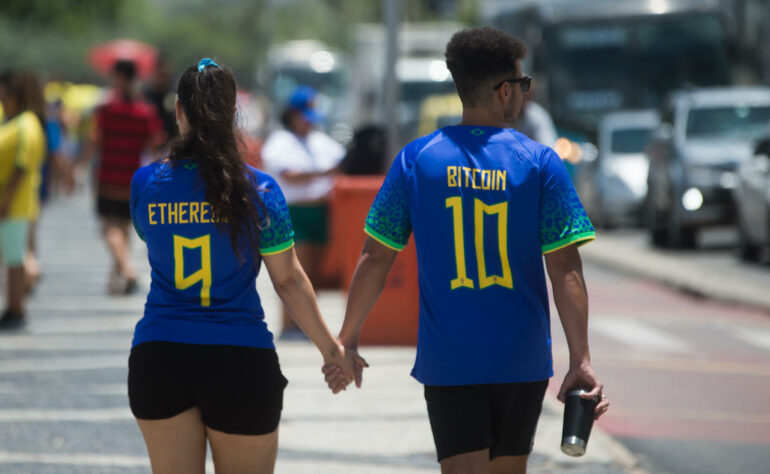 Inspirados na relação entre Brasil e Copa do Mundo, um casal chega devidamente trajado para acompanhar à partida.