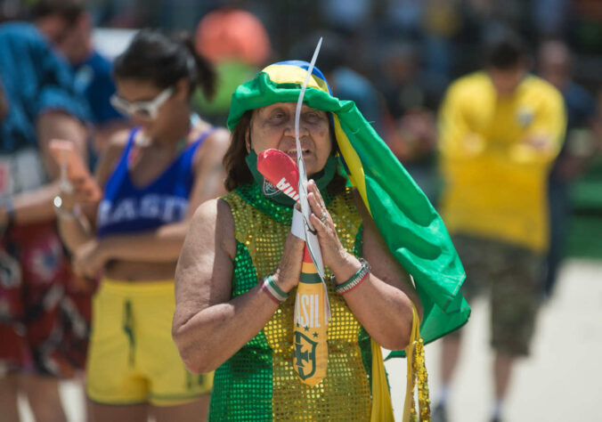 Camisas, bandeiras e adereços: as proteções da torcedora contra a aflição.