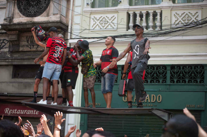 Rubro-negros em cima de um ponto de ônibus, no Centro do Rio de Janeiro.