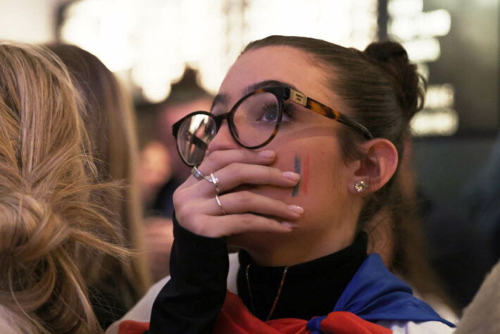 O olhar fixo da torcedora reflete o espanto do povo francês com o resultado. 