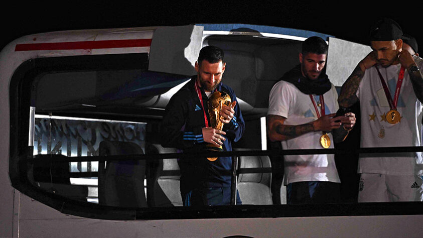 Messi não largou a taça na chegada da seleção argentina.