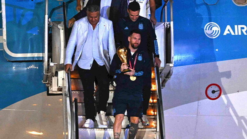 Messi desembarcou do avião com o troféu da Copa do Mundo nas mãos.