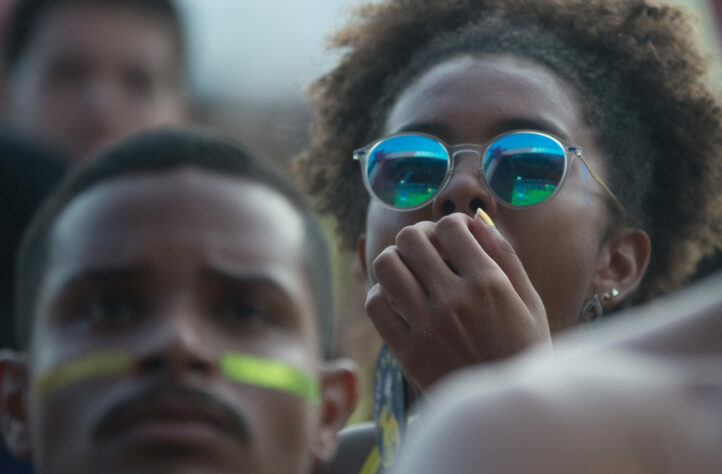 Para aliviar a ansiedade pós-jogo, a torcedora rói as unhas. Mesmo com a derrota, o Brasil avança na primeira colocação do grupo. Mas o sinal de alerta está ligado: agora não dá mais para perder.