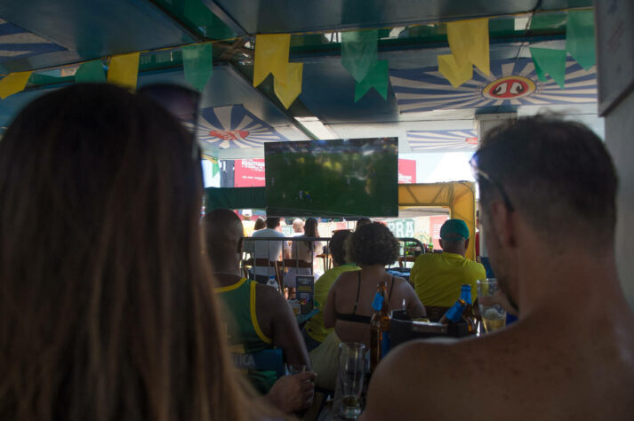 Olhos nas telas: no celular ou na televisão, os torcedores presentes no bar acompanhavam atentamente à partida.