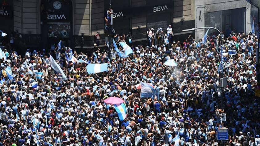 Uma multidão se espremia em uma esquina em frente ao Obelisco. 