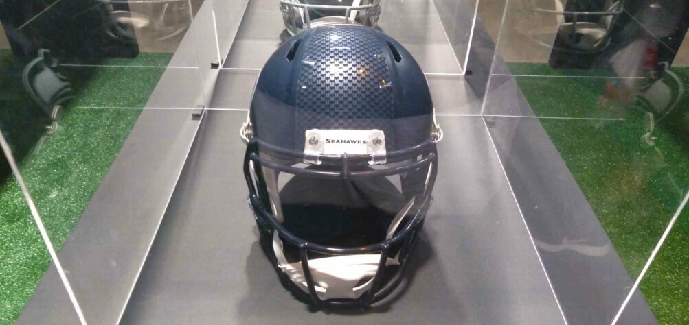 O capacete do Seattle Seahawks visto de frente. No detalhe da parte de cima, o nome da franquia. 