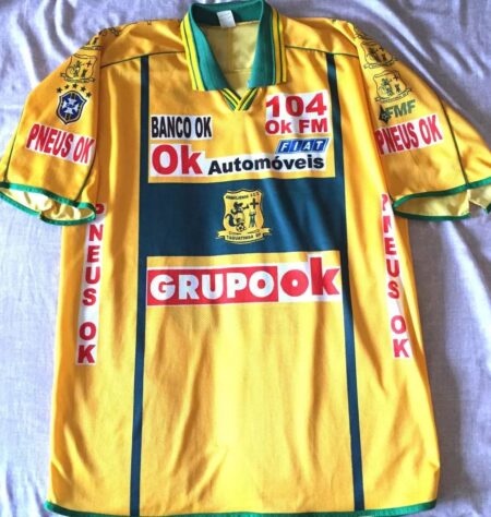 (Foto: Reprodução) Em 2005, o Brasiliense fechou um patrocínio com o Grupo Ok, assim como Ok Automóveis, Ok FM, Banco Ok e até Pneus Ok... Estampando todas as marcas em seu uniforme