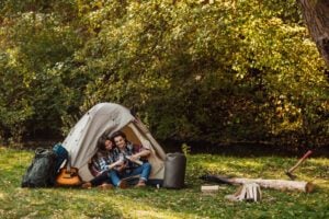 Casal acampando e usando barraca de acampamento