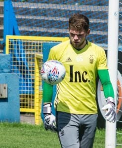 Goleiro pronto para agarrar a bola com luvas