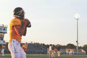 Quarterback arremessando bola de futebol americano