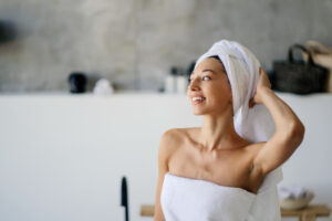 Mulher com duas toalhas após o banho