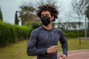 Atleta correndo de máscara.