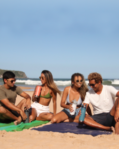 Amigos na praia com produtos Stanley-