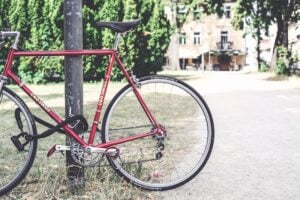 Bicicleta presa a um poste com cadeado.