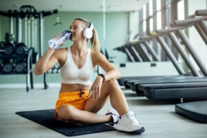 Mulher bebendo água durante o treino.