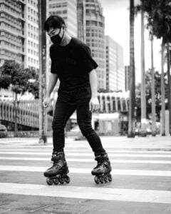 Homem usando patins pela cidade.