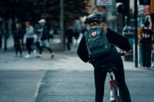 Mulher andando de bicicleta na cidade de capacete.