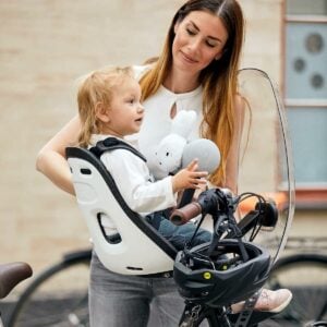 mãe instalando cadeirinha na bicicleta