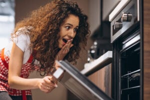 mulher cozinhando no forno elétrico