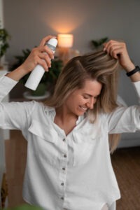 mulher aplicando protetor térmico no cabelo